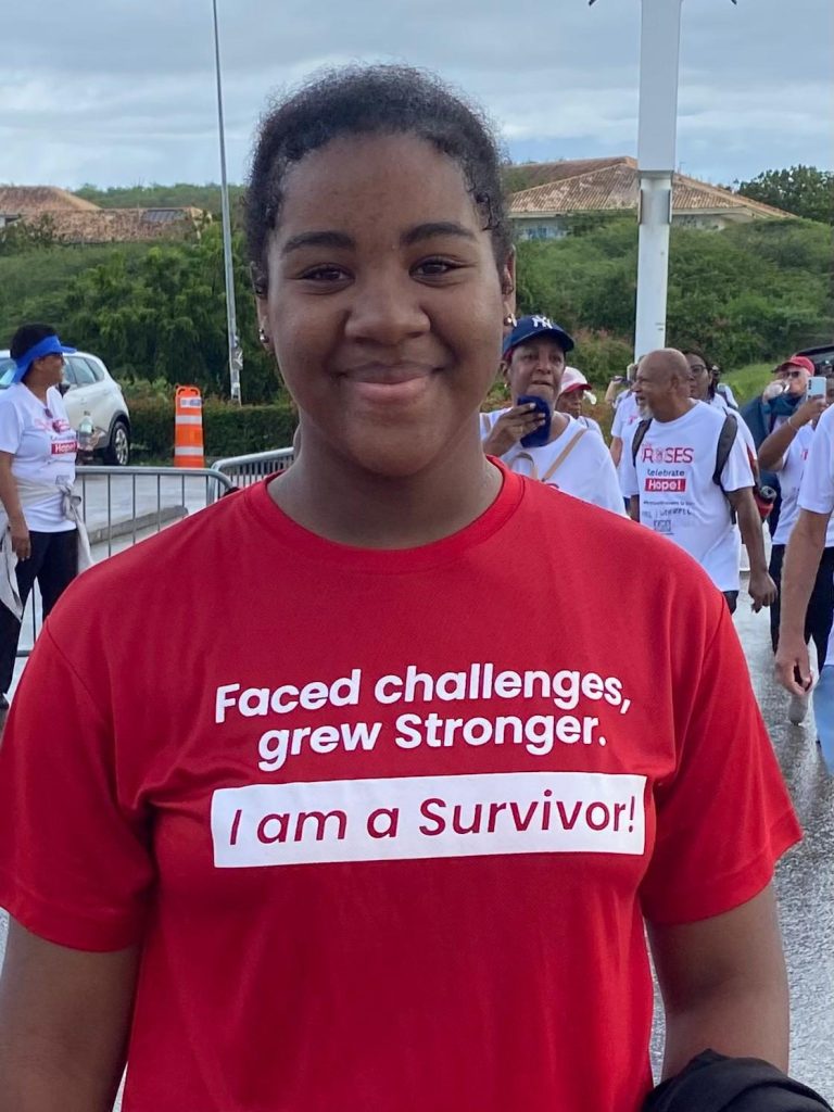 A participant in a red “I am a Survivor” shirt smiling at Ride for the Roses 2026