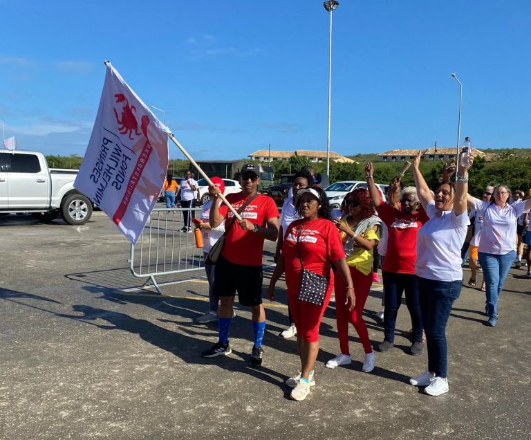 Survivors cheering with the PWF flag at the Ride for the Roses 2026 start area