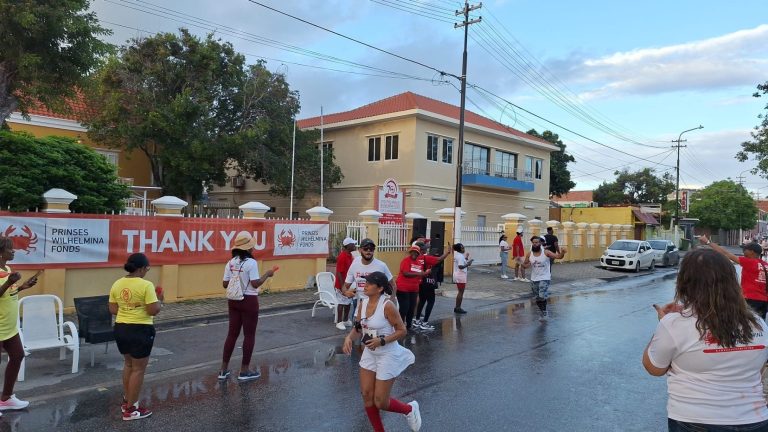 Supporters cheering a runner past the PWF thank-you banner on Scharlooweg